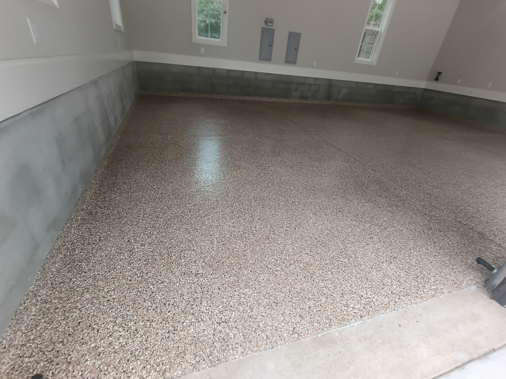 Brown flake garage floor coating with coated base of the walls
