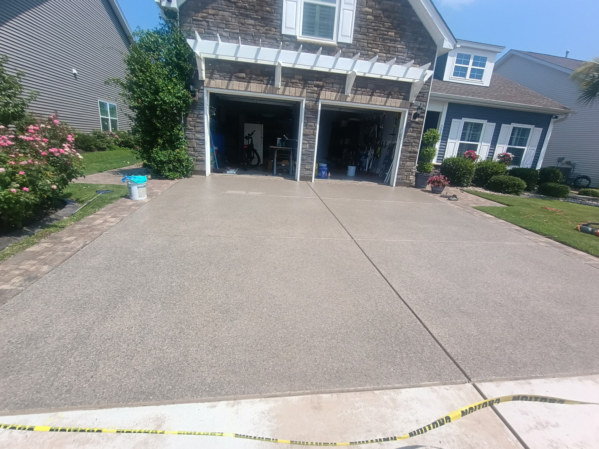 Freshly coated concrete driveway leading up to a two-car garage